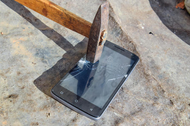 锤子和智能手机。 智能手机的屏幕，一个破碎的哈