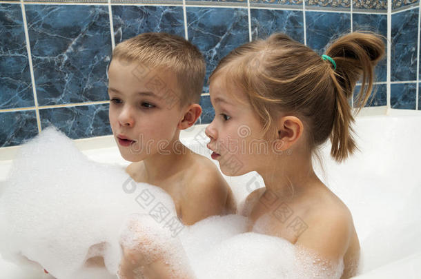哥哥和妹妹洗泡泡浴。 小男孩和女孩在玩。 保健和卫生概念。