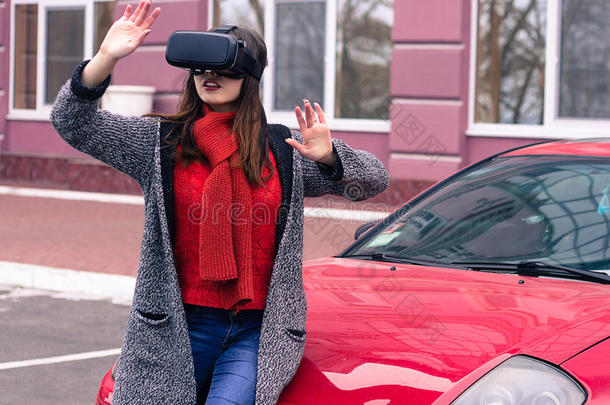 美丽的年轻女孩与虚拟现实VR耳机在红色跑车