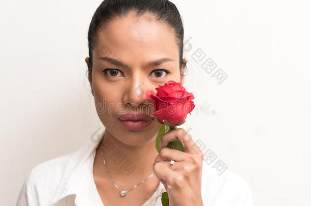 用红玫瑰亲近美丽的亚洲女人