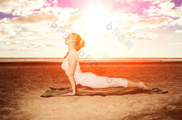<strong>日</strong>出时，年轻美丽的苗条女人在海滩上练习<strong>瑜伽</strong>。<strong>日</strong>落<strong>瑜伽</strong>
