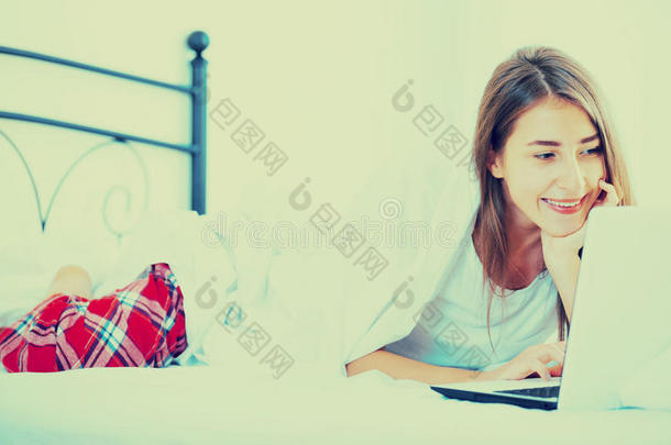 开朗的学生女孩在床上<strong>学习笔记</strong>本电脑