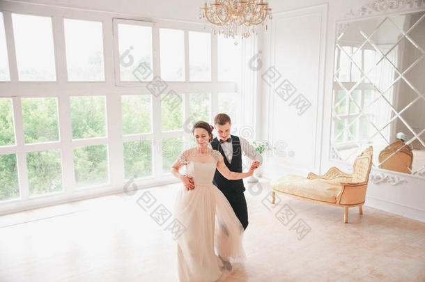 第一次婚礼丹克。婚礼夫妇在工作室跳舞。 结婚那天。 新婚快乐的年轻新娘和新郎。
