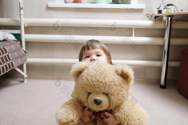 孩子拥抱泰迪熊，奉献的概念，孩子躲在玩具后面