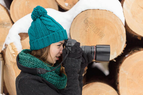 女孩在冬天拍摄一台大相机