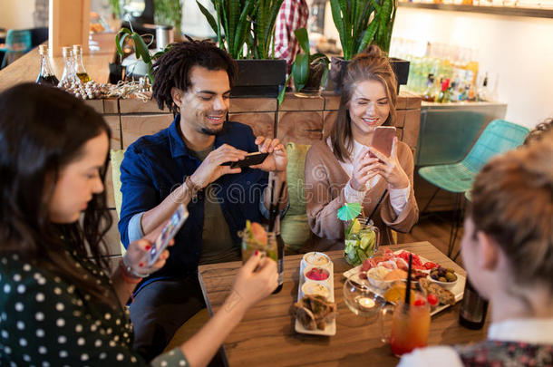 在餐厅有智能手机和食物的朋友