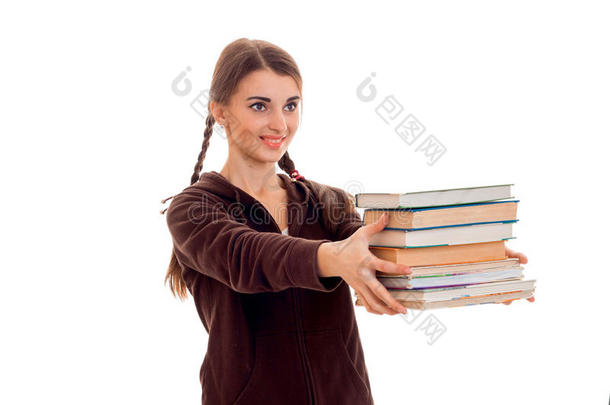 开朗的年轻学生女孩，带着棕色运动服的书，在白色背景上微笑着。 学生年