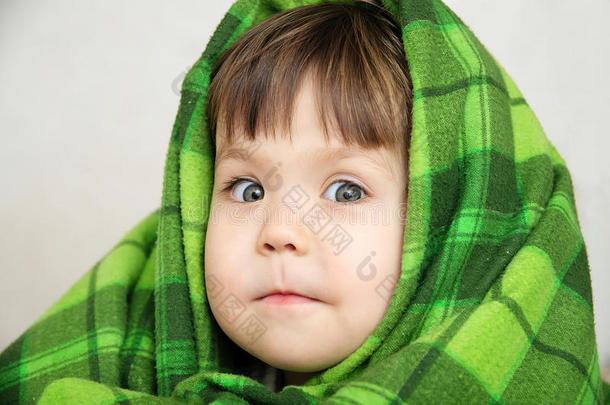 有趣的儿童肖像在毯子温暖，快乐的笑脸表达情感，小女孩看着相机，温暖的毯子