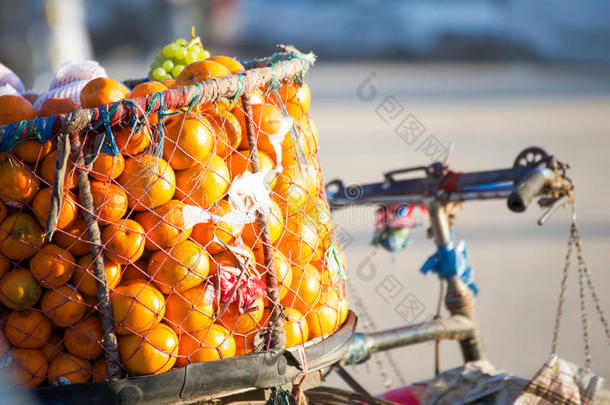 自行车上篮子里的新鲜橙色出售