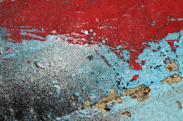 旧损坏的墙壁上开裂的剥落的红色和绿松石油漆