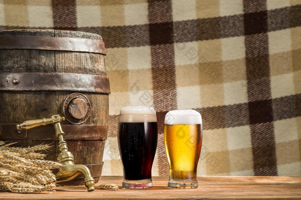 <strong>木制</strong>桌子上的一杯啤酒和啤<strong>酒桶</strong>。