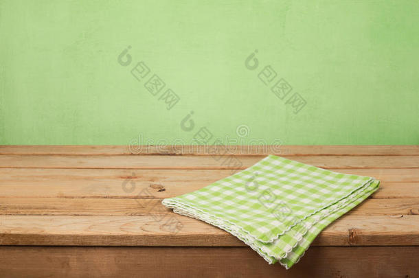 空木甲板桌子，在绿色的墙壁背景上有经过检查的桌布