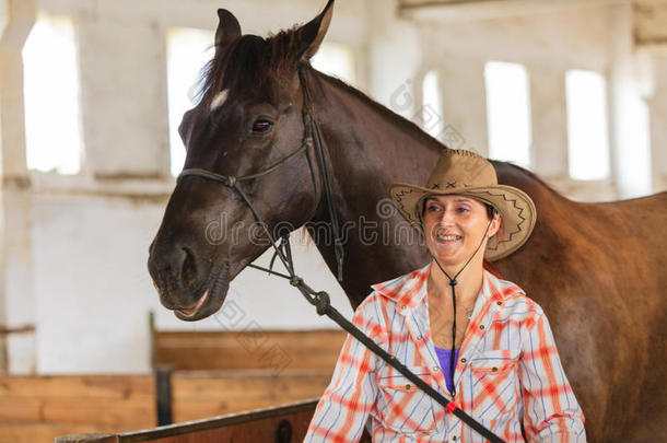 牛仔女孩站在棕色的马朋友旁边