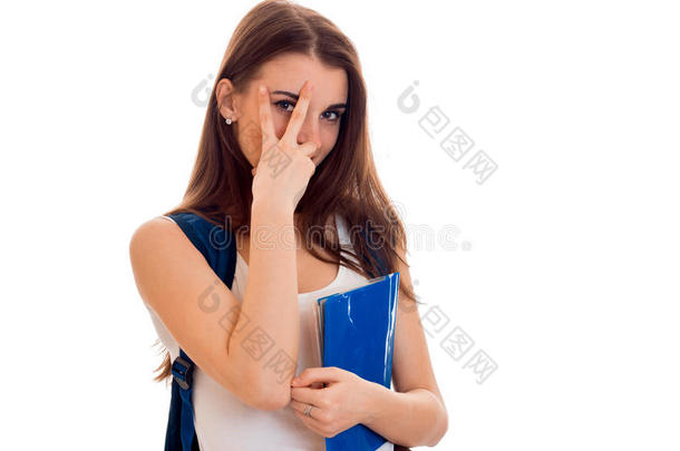 开朗聪明的学生女孩穿着棕色运动服，肩上背着背包，手里拿着笔记本