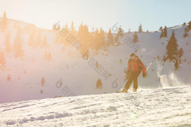 滑雪者在高山上迎着日落滑雪