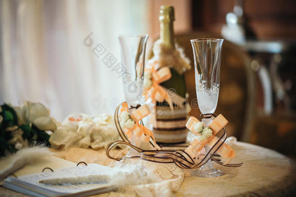 带婚礼装饰的香槟杯和一瓶香槟