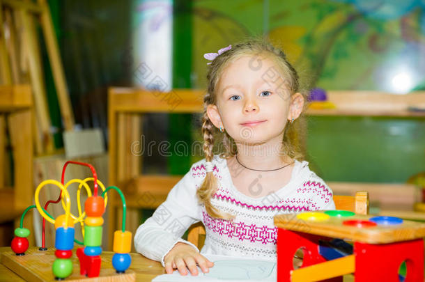可爱的女孩在托儿所玩教育玩具。 蒙台梭利学前班幼儿园的孩子。