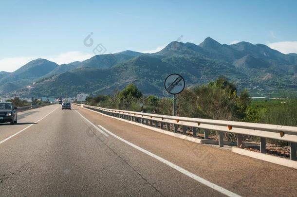 汽车沿着高速公路行驶，穿过西班牙沿海的山麓和山脉。