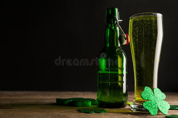圣帕特里克节的一杯绿色啤酒、啤酒瓶和三叶草