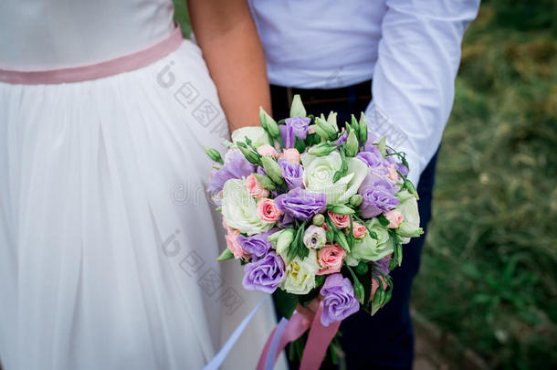 新娘和新郎一起拿着婚礼花束。 新婚夫妇。 新娘和新郎。