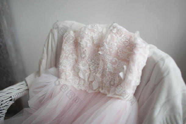 美丽的，粉红色的，浅色的薄纱和花边躺在椅子上。 婚礼的概念