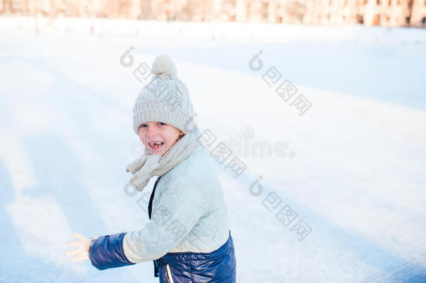 可爱的小女孩在冬天的雪天在户外滑冰