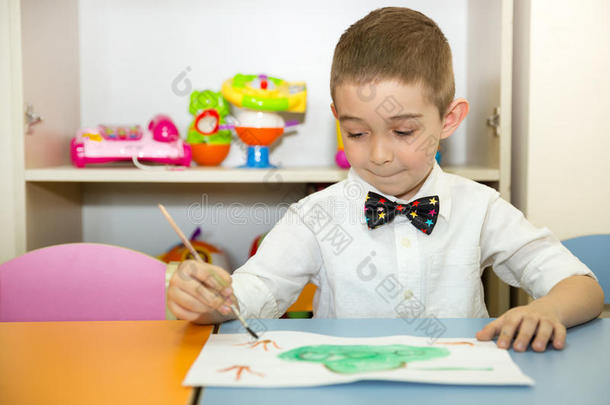 可爱的小男孩在<strong>托</strong>儿所画了一把刷子和颜料。 蒙台梭利学前<strong>班幼儿园</strong>的孩子。
