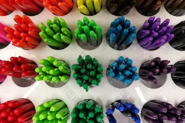 五颜六色的钢笔在文具店或百货公司的货架上聚焦在地面上的圆珠笔与模糊的背景，五颜六色的h