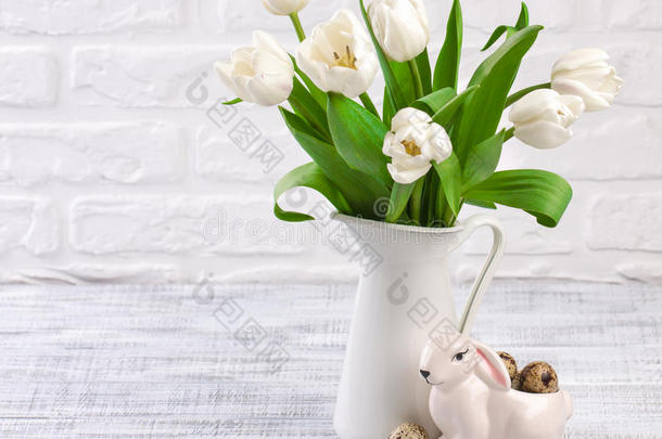 复活节的组成与鸡蛋，春天郁金香和瓷器复活节兔子在旧的木桌上