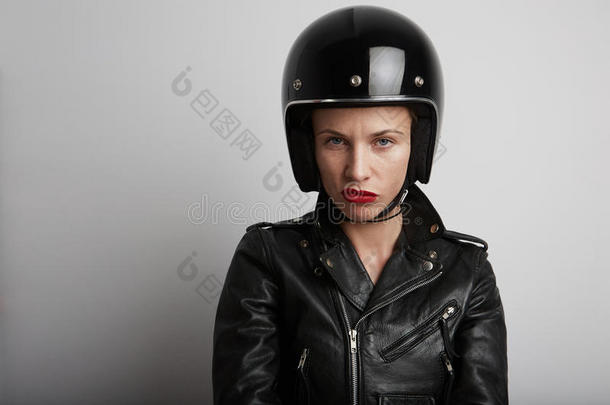 在白色背景下，穿着时尚的黑色<strong>运动</strong>头盔和皮<strong>夹克</strong>的自行车女子的特写肖像。