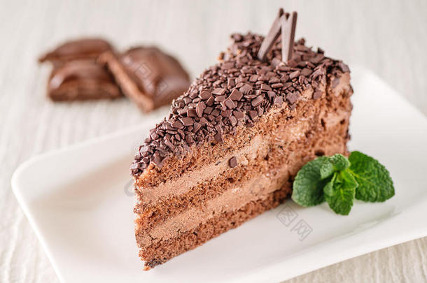 巧克力或咖啡奶油蛋糕在白色盘子与薄荷叶，无麸质蛋糕，产品摄影的糕点