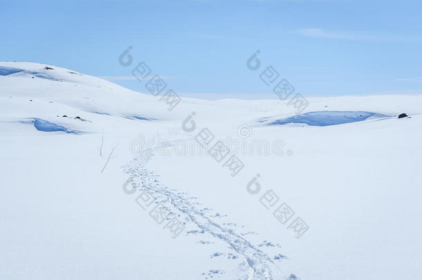 晴朗的天空和滑雪轨道在冬天的景观雪覆盖的山脉