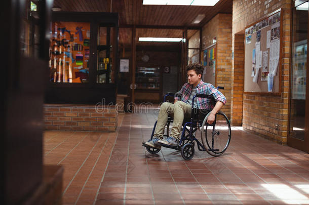 在学校走廊坐轮椅的残疾学童