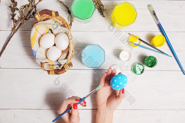 把五颜六色的复活节彩蛋放在篮子里。 刷和油漆