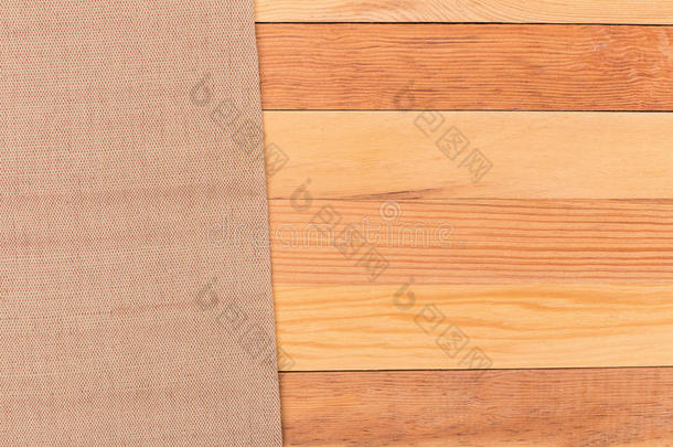 木桌上的布料。 软棕色编织亚麻织物纹理