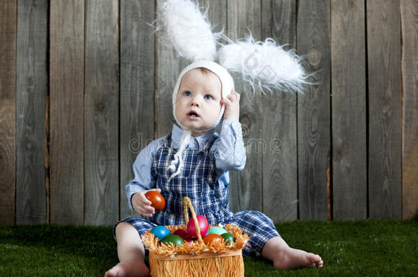 孩子穿着兔子服装，带着一篮子五颜六色的鸡蛋