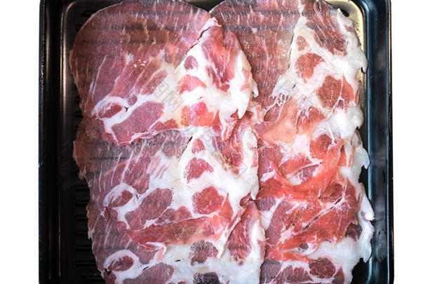 新鲜猪肉切片在黑色方形塑料板顶部视图隔离
