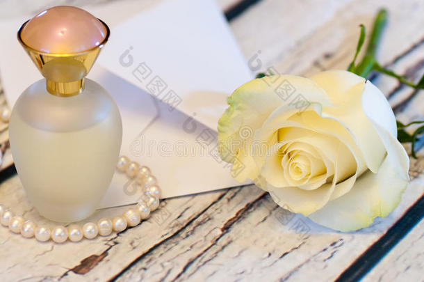 美丽的白色玫瑰串珍珠香水瓶和信封爱情人节`