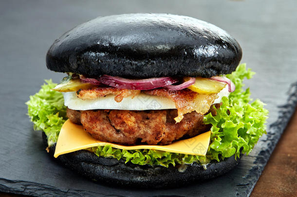 黑色背景的石桌上的黑色汉堡包快餐餐美味的