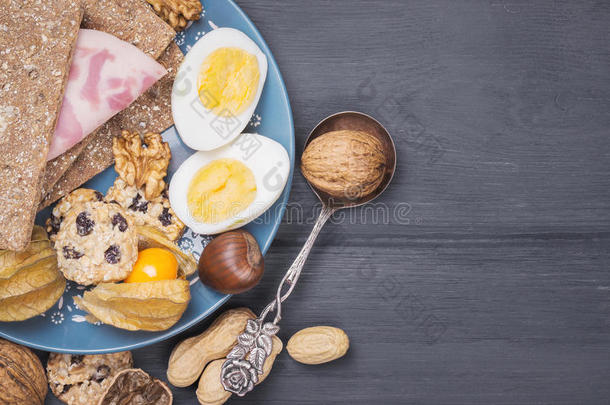 早餐背景与坚果，鸡蛋，面包在木板上。