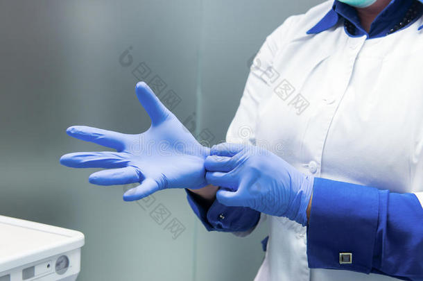 戴手套的医生的手。