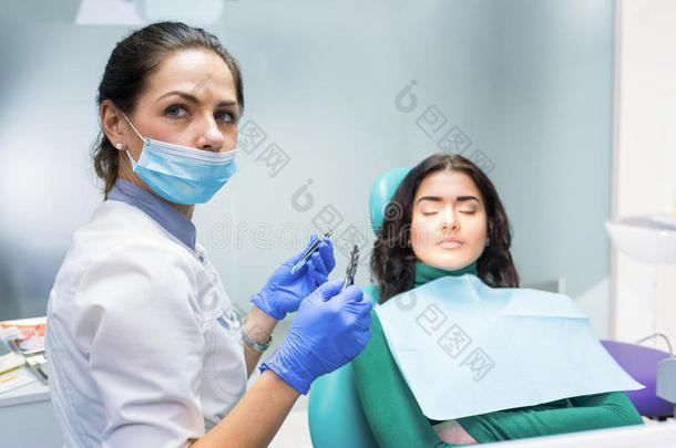 女牙医拿着钳子。