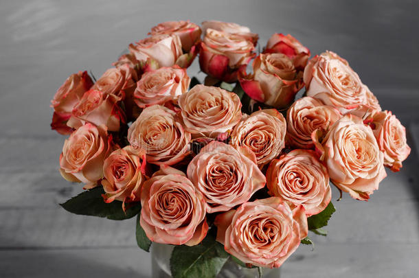 鲜花。 木桌上的一束卡普奇诺玫瑰。 老式情人节花背景。