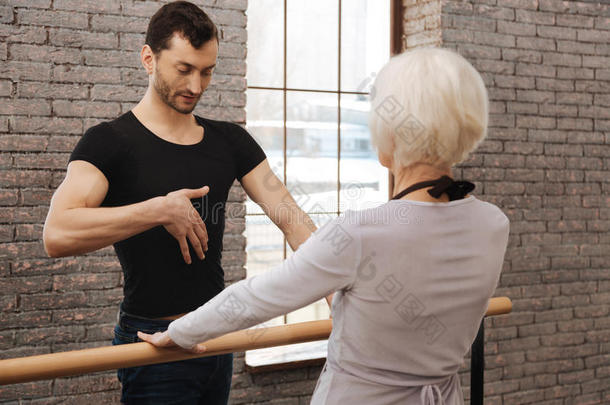 自信的舞蹈老师在舞蹈工作室指导老妇人