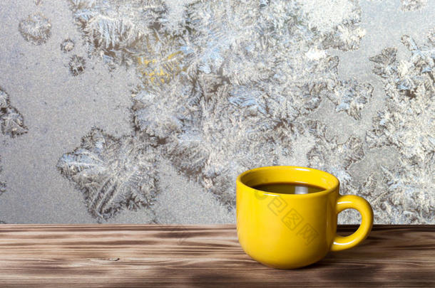 咖啡或茶在<strong>黄色</strong>的杯子在木桌上，相反的美丽的自然图案在<strong>磨砂</strong>玻璃上作为<strong>背景</strong>。 拼贴。