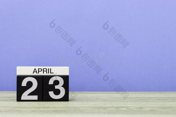 四月二十<strong>三日</strong>。每月二十<strong>三日</strong>，木制桌子上的日历和紫色背景。春天，文字空白