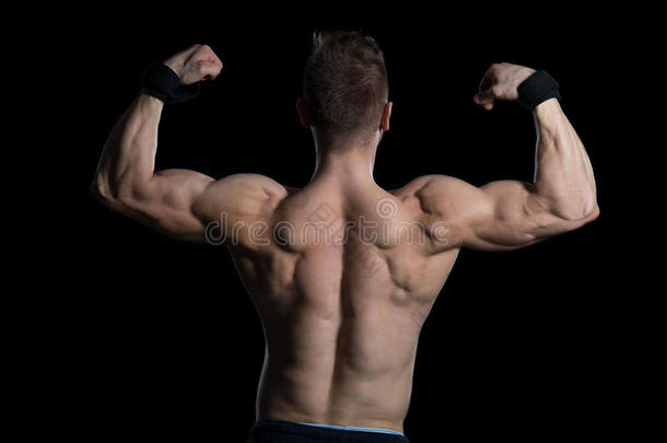肌肉发达的男人在黑色背景下伸展肌肉