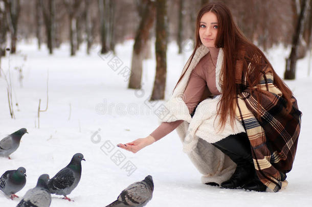 女孩，长发裹在毯子和鸽子里，在冬天的帕里
