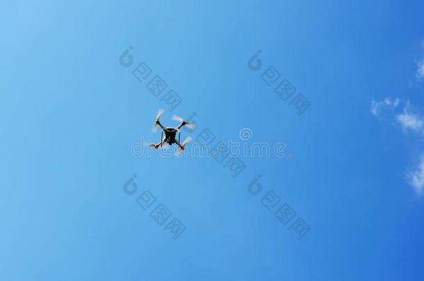 无人机四翼直升机与数码相机飞行盘旋在蓝天