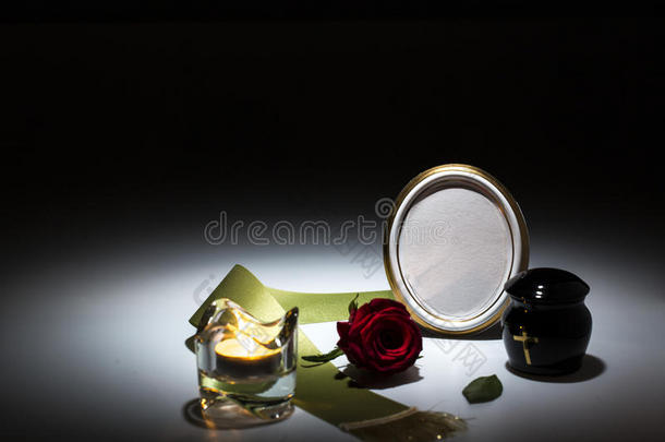 黑色骨灰盒，绿色胶带，玫瑰，蜡烛，同情卡